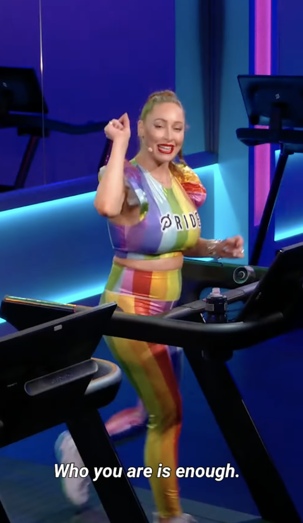 A female presenting Peloton instructor running on a treadmill wearing a flashy rainbow workout outfit from Peloton's Pride-inspired collection of branded workout wear.